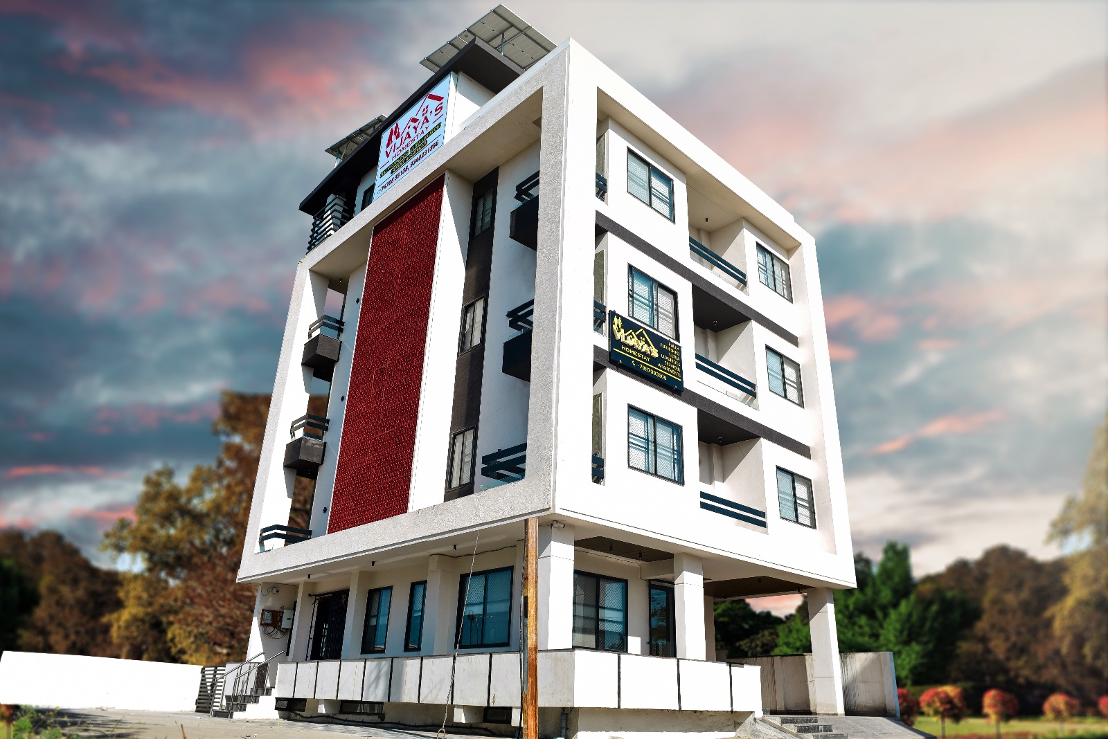 The red and white facade of Vijaya's Homestay Indore, a charming serviced apartment building in Indore